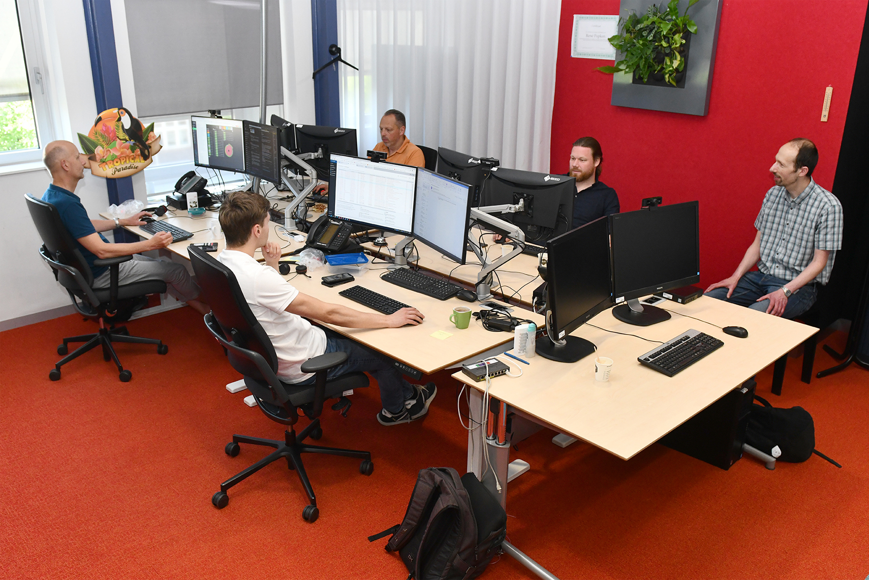 Vijf medewerkers achter computer schermen